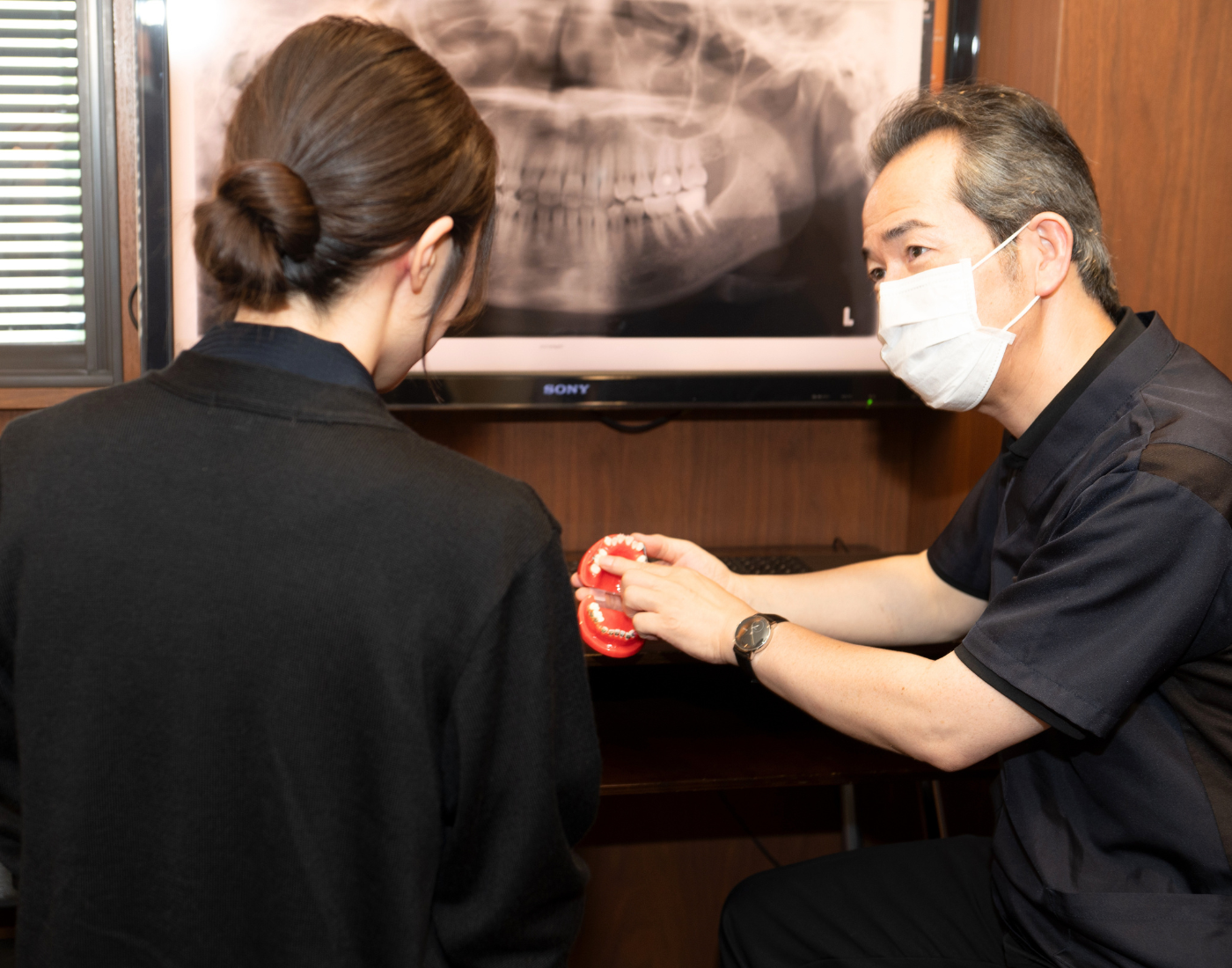 検査画像を確認しながら矯正治療について説明する歯科医師